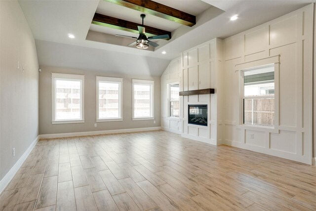 unfurnished living room featuring ceiling fan, beamed ceiling, light wood-type flooring, and a large fireplace