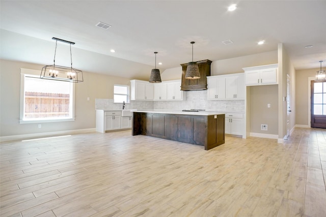 kitchen with white cabinetry, a center island, and decorative light fixtures