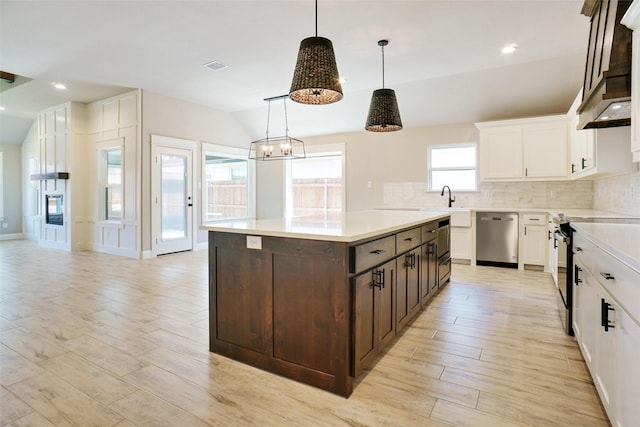 kitchen featuring range with electric cooktop, decorative light fixtures, dishwasher, a center island, and dark brown cabinetry