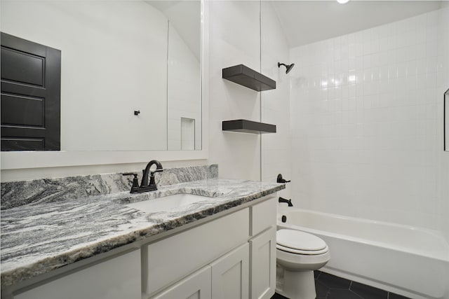 full bathroom featuring tile patterned flooring, toilet, vanity, and tiled shower / bath