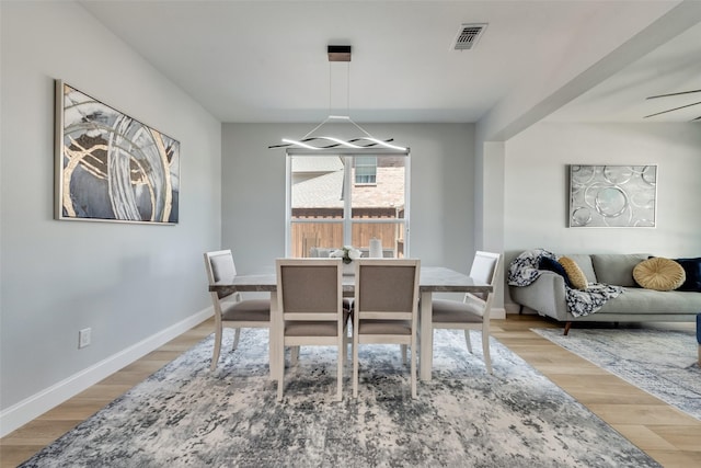 dining area with ceiling fan and light hardwood / wood-style flooring