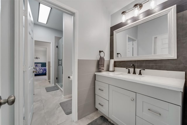 bathroom with an enclosed shower, vanity, and a skylight