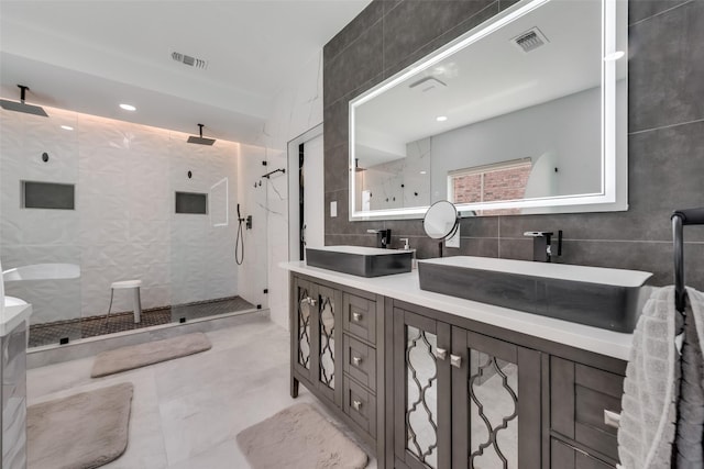 bathroom featuring walk in shower, vanity, and tile walls