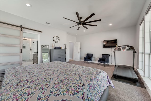 carpeted bedroom featuring ceiling fan, a barn door, ensuite bathroom, and multiple windows