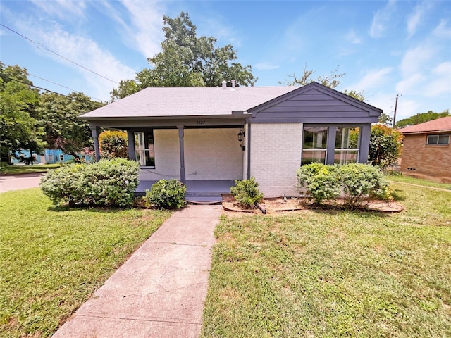 bungalow-style home featuring covered porch and a front lawn