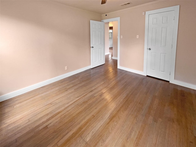 unfurnished bedroom with ceiling fan, crown molding, and wood-type flooring