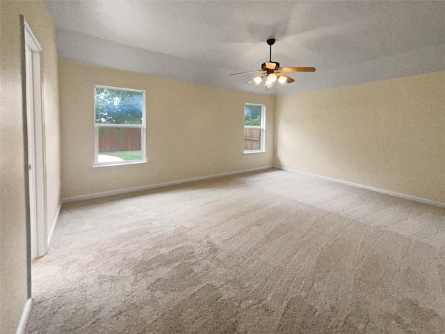 spare room with ceiling fan and light colored carpet