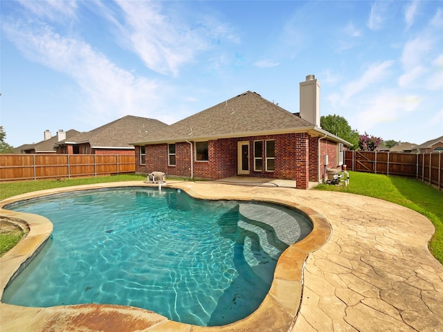 view of swimming pool featuring a lawn and a patio