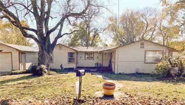 single story home with a garage and a front lawn