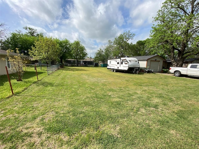 view of yard with a garage and an outbuilding