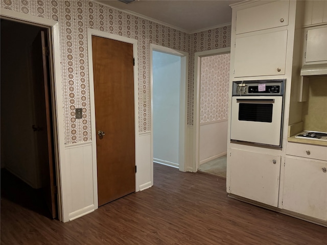 kitchen with stovetop, dark hardwood / wood-style floors, wall oven, and white cabinets