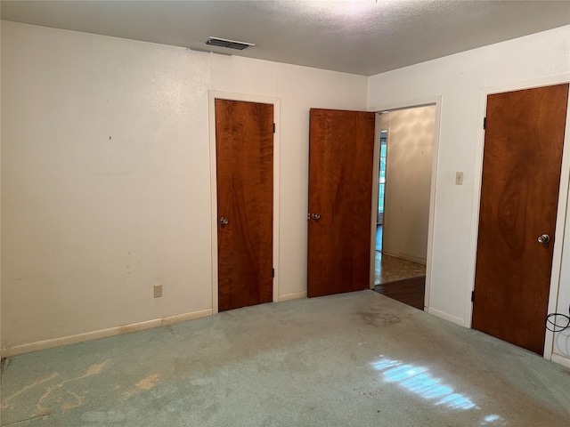 unfurnished bedroom featuring carpet and a textured ceiling