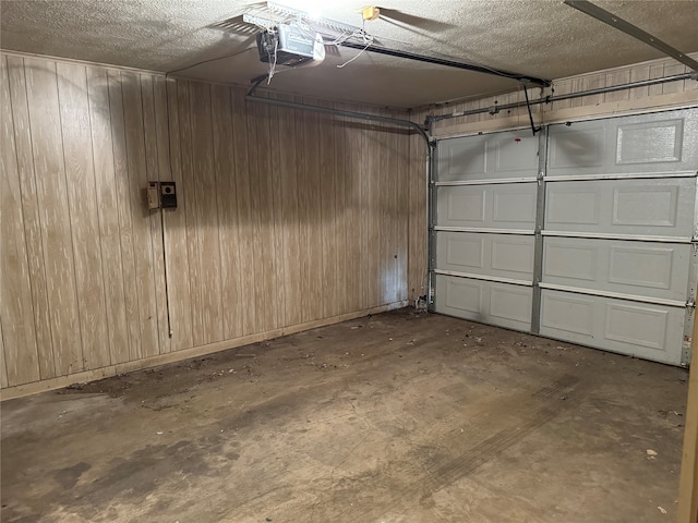 garage with wood walls and a garage door opener