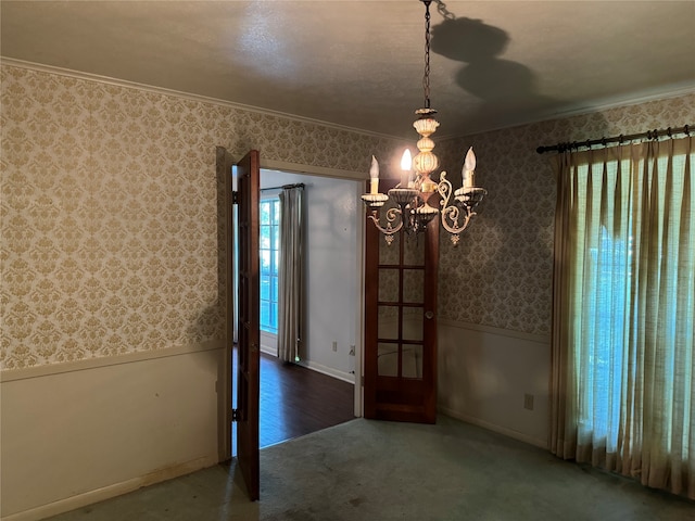 spare room with a notable chandelier, crown molding, and hardwood / wood-style floors