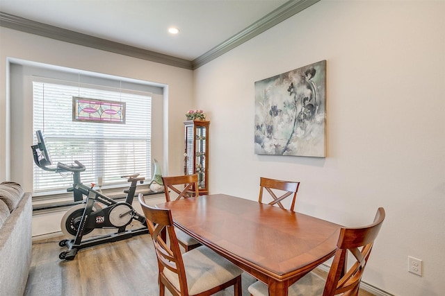 dining space featuring hardwood / wood-style floors and crown molding