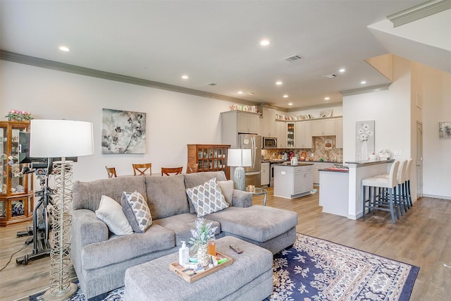 living room featuring light wood-type flooring and crown molding