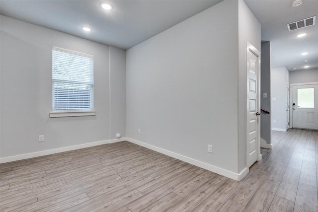 spare room with plenty of natural light and light hardwood / wood-style flooring