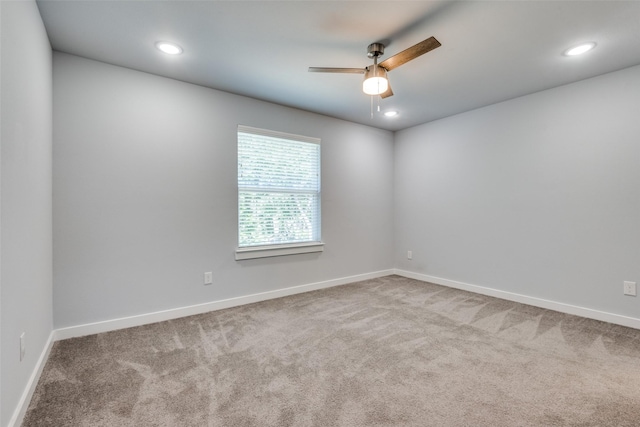 carpeted spare room featuring ceiling fan