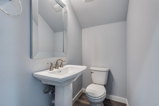 bathroom featuring toilet, sink, and hardwood / wood-style floors