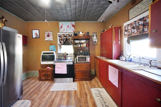 kitchen featuring sink, light hardwood / wood-style flooring, stainless steel appliances, and a wealth of natural light