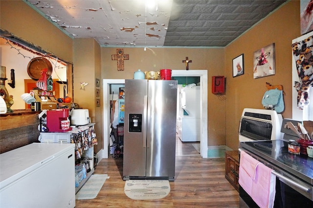 kitchen featuring stainless steel refrigerator with ice dispenser, hardwood / wood-style flooring, and fridge