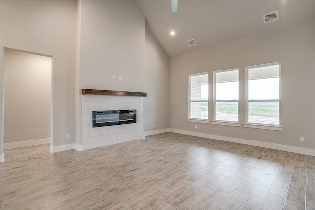 unfurnished living room featuring high vaulted ceiling and light hardwood / wood-style floors