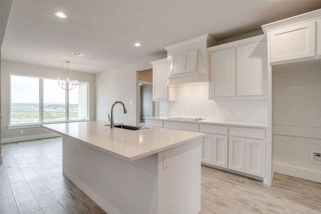 kitchen featuring white cabinetry, a kitchen island with sink, and sink