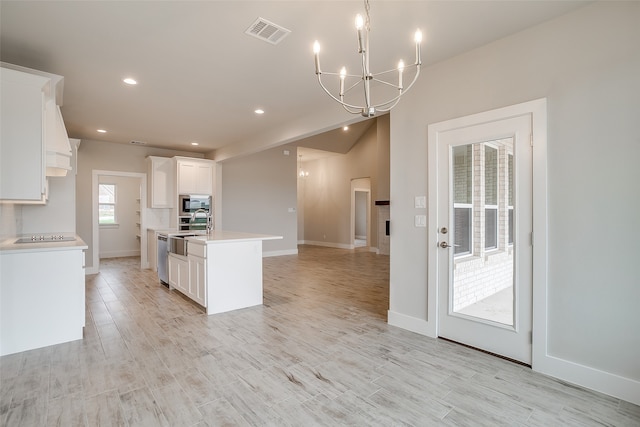 kitchen with light wood-type flooring, stainless steel dishwasher, a center island with sink, and white cabinets