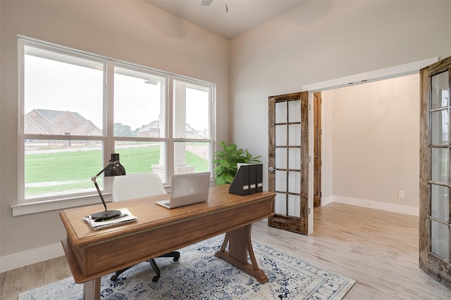 home office featuring ceiling fan and light hardwood / wood-style floors