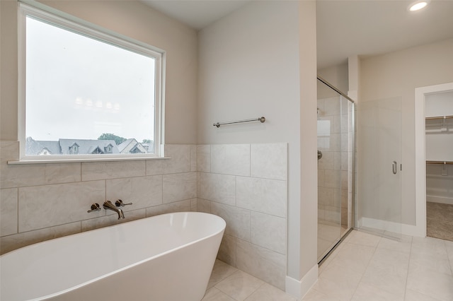 bathroom with separate shower and tub and tile patterned flooring