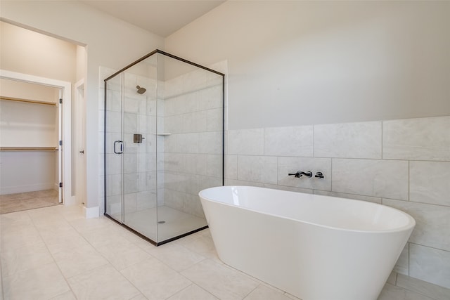 bathroom with tile walls, tile patterned floors, and independent shower and bath