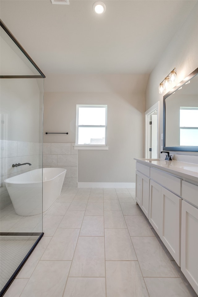 bathroom featuring tile walls, vanity, a bathing tub, tile patterned floors, and vaulted ceiling