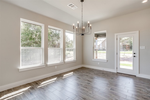 unfurnished dining area with a chandelier and dark wood-type flooring