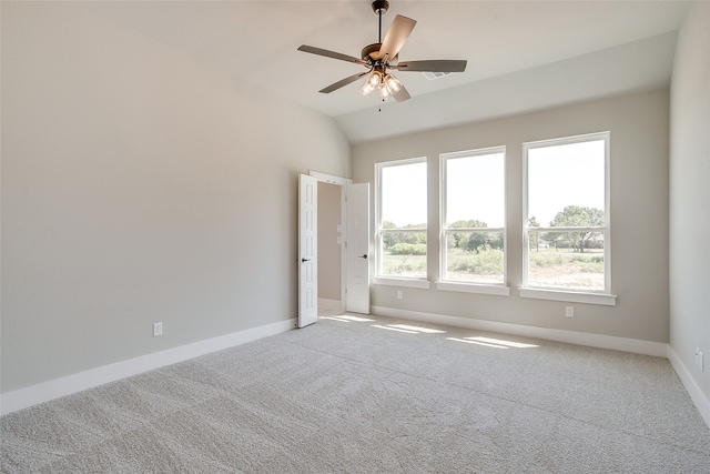 empty room featuring lofted ceiling, light carpet, and ceiling fan