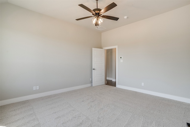 empty room featuring lofted ceiling, ceiling fan, and carpet flooring