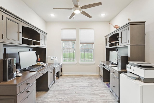 home office featuring built in desk, light hardwood / wood-style floors, and ceiling fan