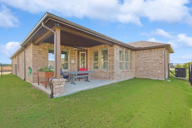 rear view of property featuring central AC, ceiling fan, a yard, and a patio