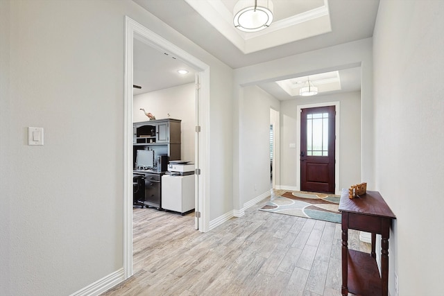 foyer featuring light wood-type flooring and a raised ceiling