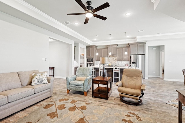 living room featuring ornamental molding, ceiling fan, and light wood-type flooring