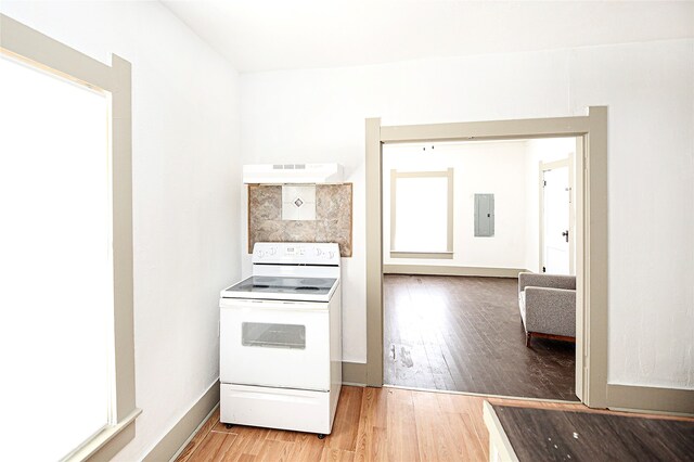 kitchen with white electric range, wood-type flooring, electric panel, and premium range hood