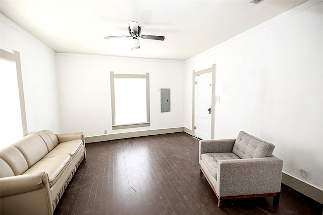 living area with electric panel, ceiling fan, crown molding, and dark wood-type flooring