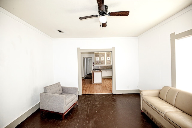 living area with ornamental molding, ceiling fan, and dark hardwood / wood-style floors