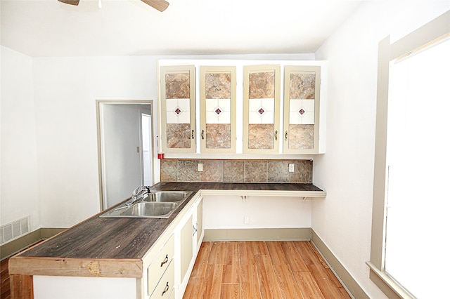 kitchen with white cabinetry, butcher block counters, ceiling fan, light hardwood / wood-style floors, and sink