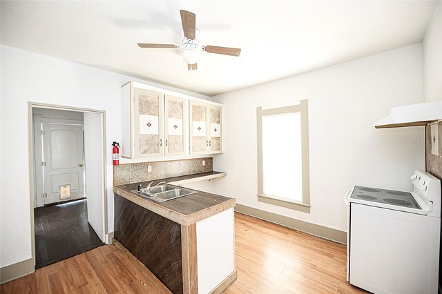 kitchen with washer / clothes dryer, light hardwood / wood-style flooring, sink, and white cabinets