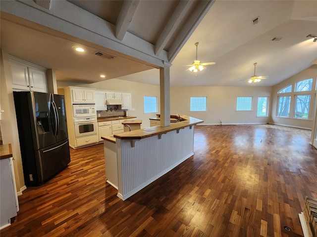 1457 Riverside Dr, West Tawakoni, TX 75474 - kitchen featuring butcher block countertops, black fridge with ice dispenser, visible vents, and white oven