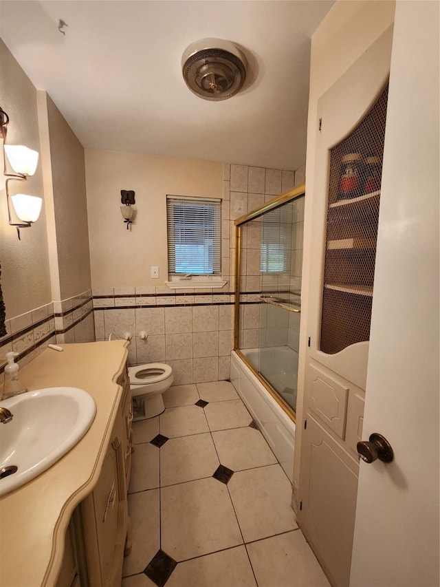 1457 Riverside Dr, West Tawakoni, TX 75474 - full bath with tile patterned flooring, shower / bath combination with glass door, vanity, tile walls, and toilet