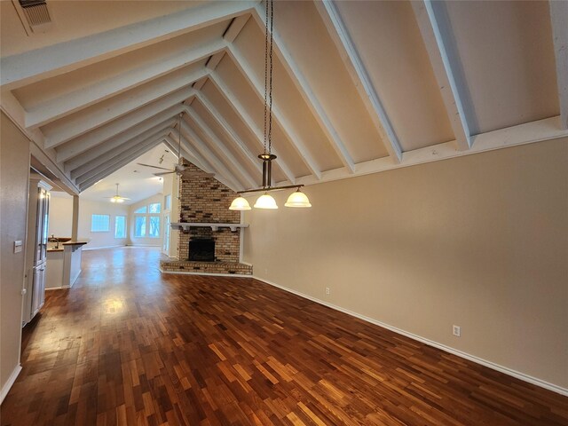 1457 Riverside Dr, West Tawakoni, TX 75474 - unfurnished living room featuring dark wood finished floors, baseboards, vaulted ceiling with beams, and a brick fireplace