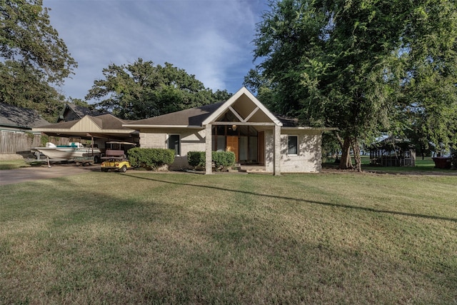 1457 Riverside Dr, West Tawakoni, TX 75474 - view of front of house with driveway, a carport, fence, and a front lawn