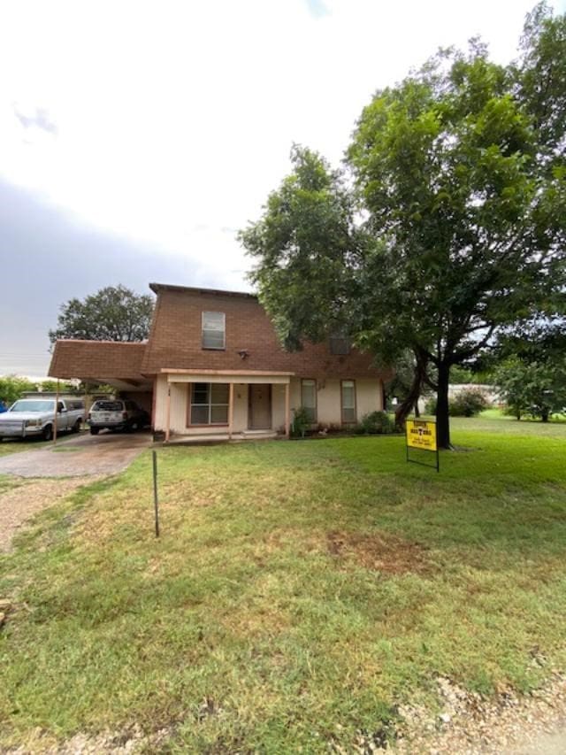 view of front of house with a carport and a front lawn