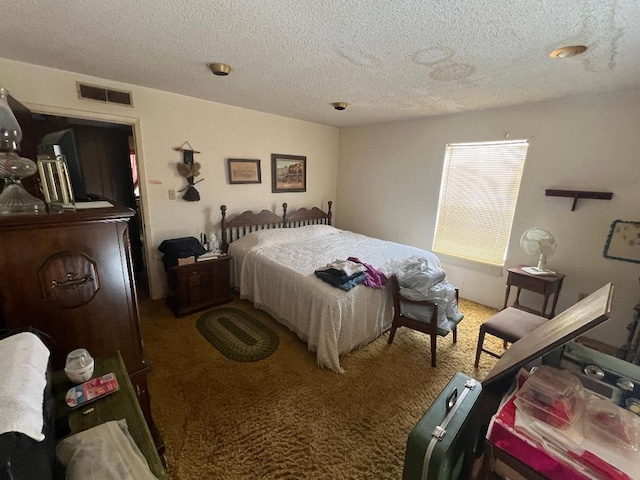 bedroom featuring a textured ceiling and carpet flooring